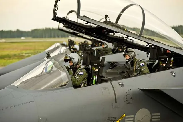 Two aircrew seated in the tandem cockpit of an F-15K with the canopy raised