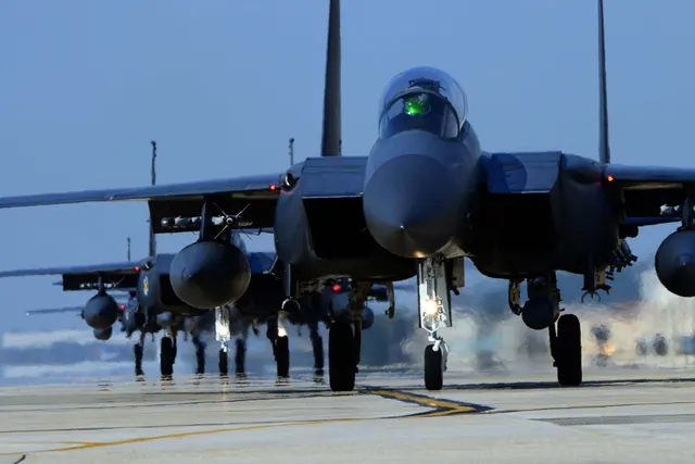 A line of F-15Ks taxiing head-on with heat haze rising behind them