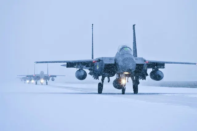 F-15Ks taxiing through heavy falling snow with landing lights on