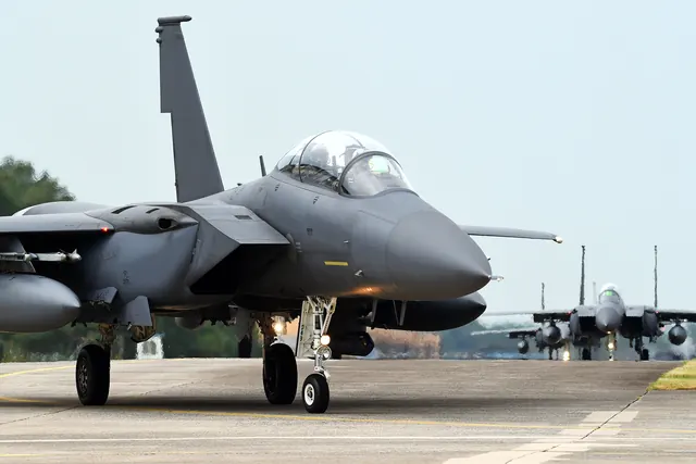 An F-15K taxiing towards the camera with another aircraft behind it on the runway