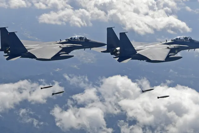 Two F-15Ks releasing four bombs above broken cloud